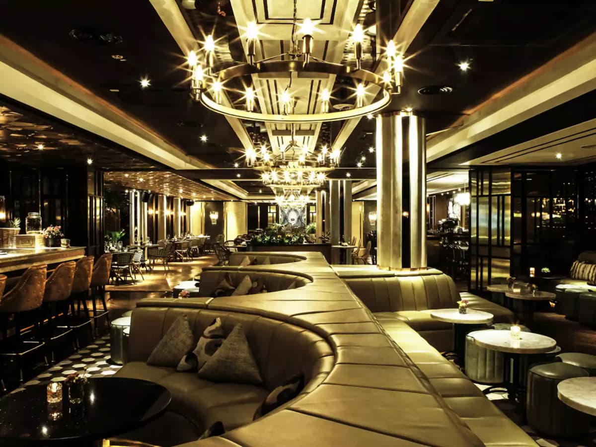 private cushioned booths in front of a long bar area
