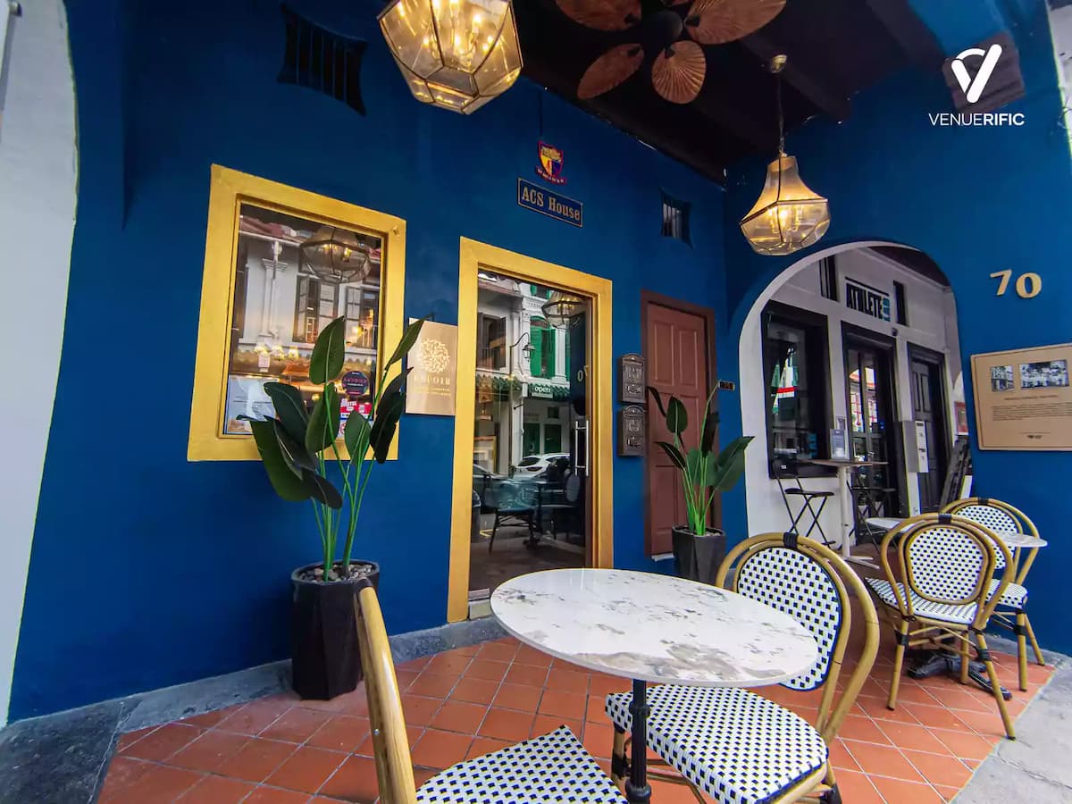 side view of a blue building with tables and chairs
