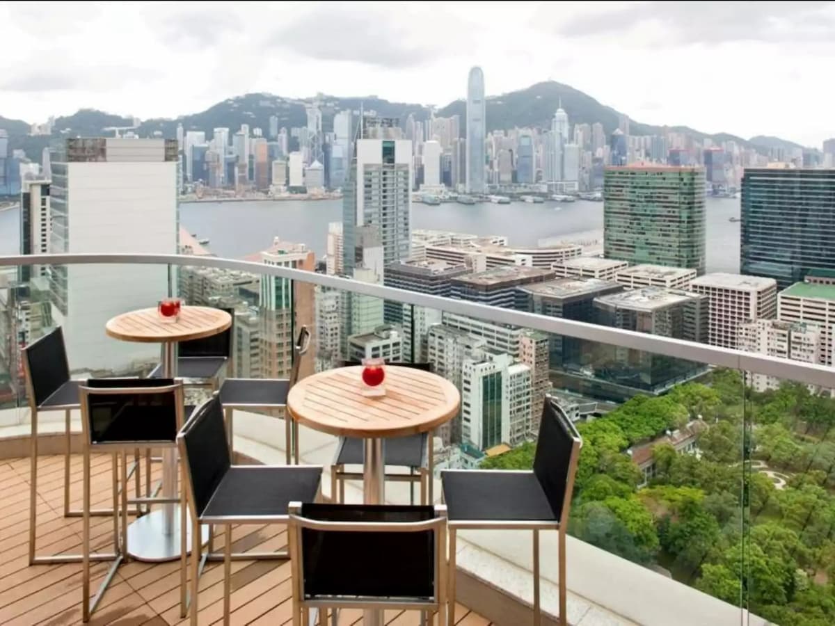 rooftop seating area with panoramic view of hong kong skyline
