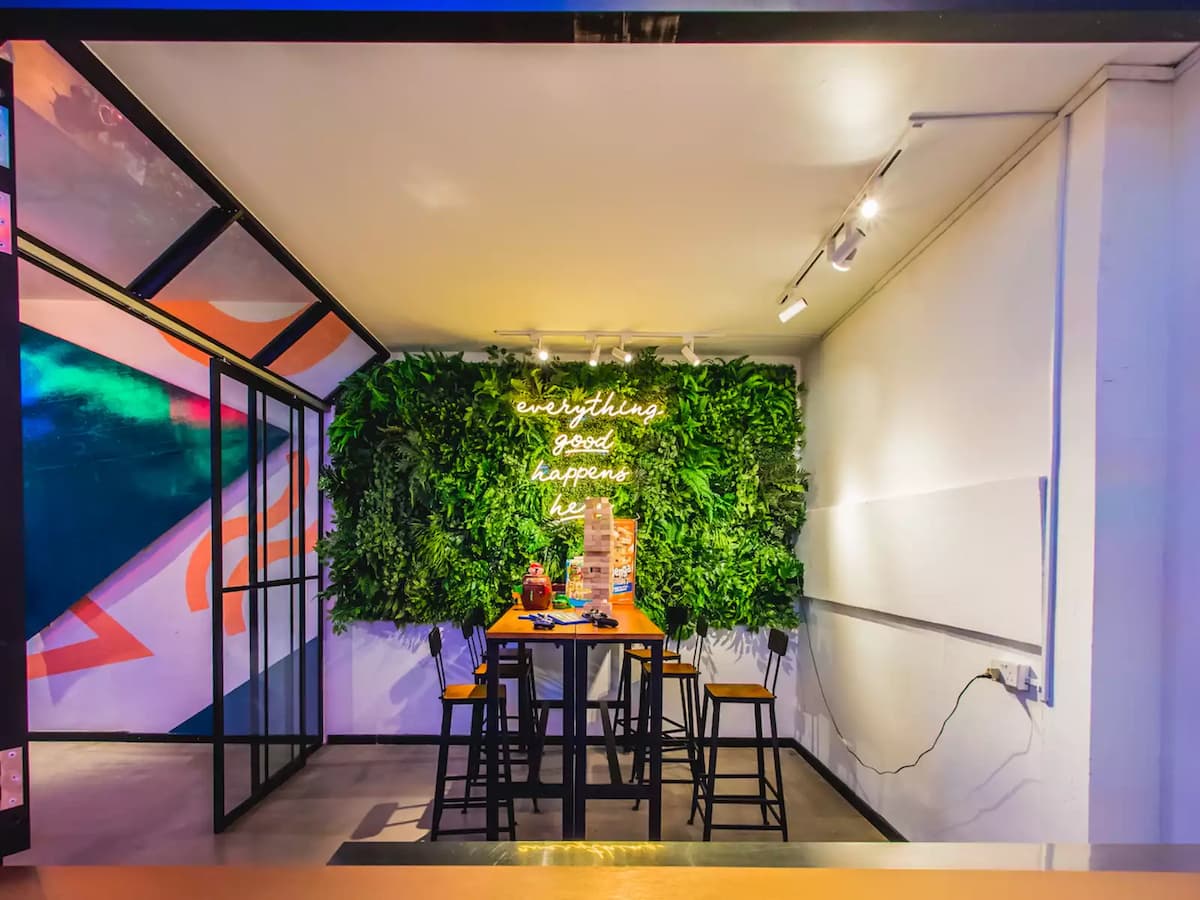 office party event venue in singapore with dining table and lush green wall with neon lights