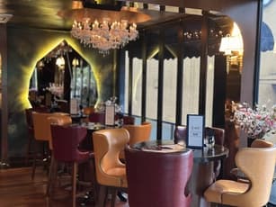small event dining space with chandelier leather chairs round tables and floral decorations