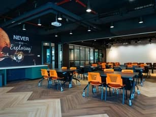 two people having a meeting at small round table against worq event space wall with wood flooring