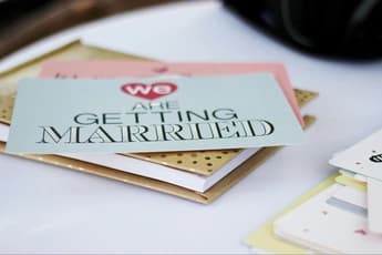 close up of stack of cards with top card reading we are getting married