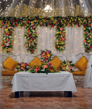indoor venue with curtain lights colorful flower arrangements and long cushions