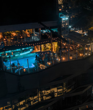 illuminated rooftop venue with multi-level seating pool area and surrounding city lights