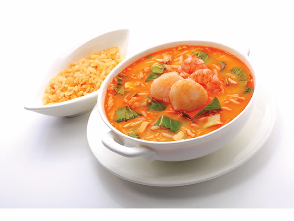 tom yum soup served on the bowl at the table