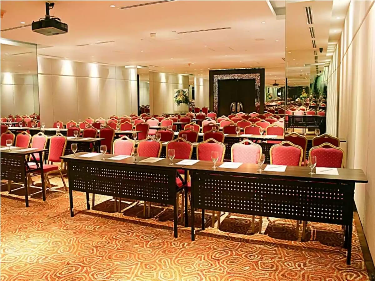 manila function hall with black long tables and red audience chairs