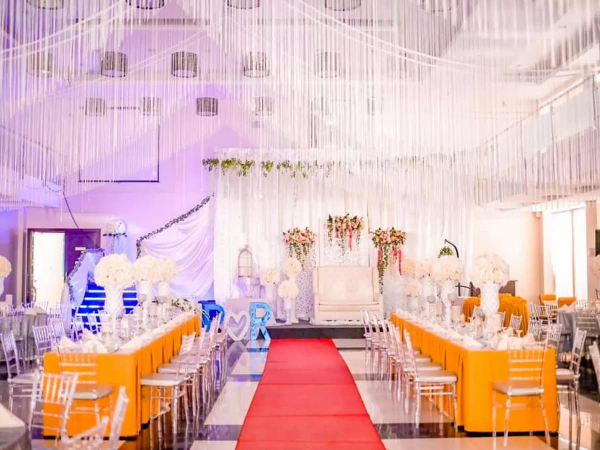 indoor wedding reception with long table setup and red carpet