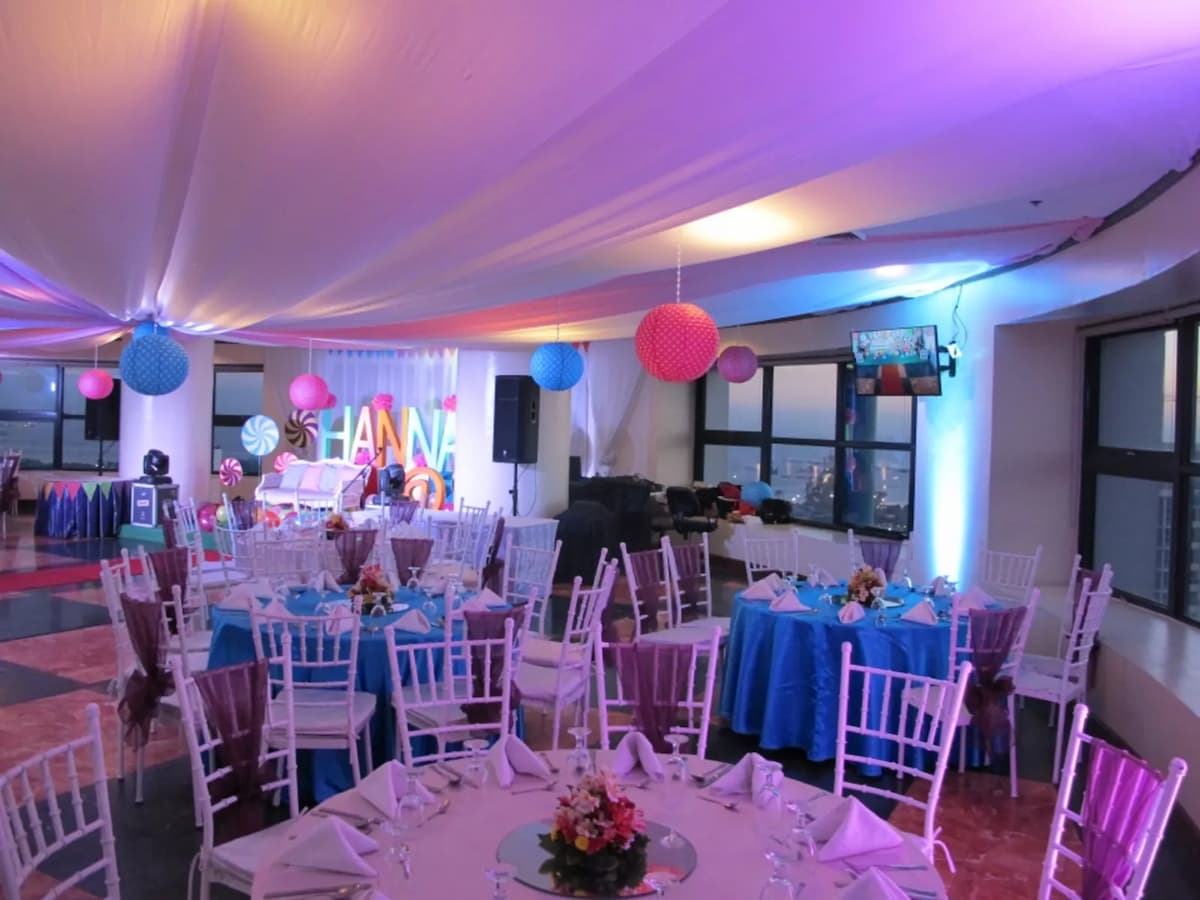 birthday party event space in manila with white round tables and colourful hanging decoration