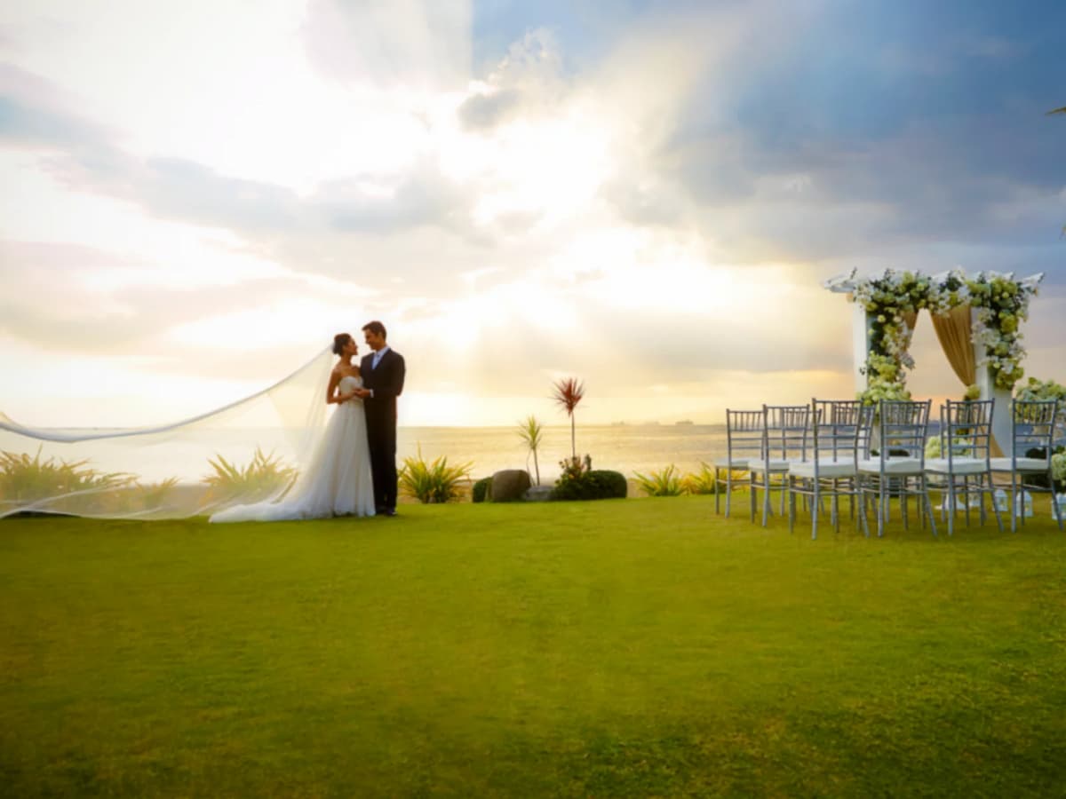 bridge and groom embracing next to garden wedding setup