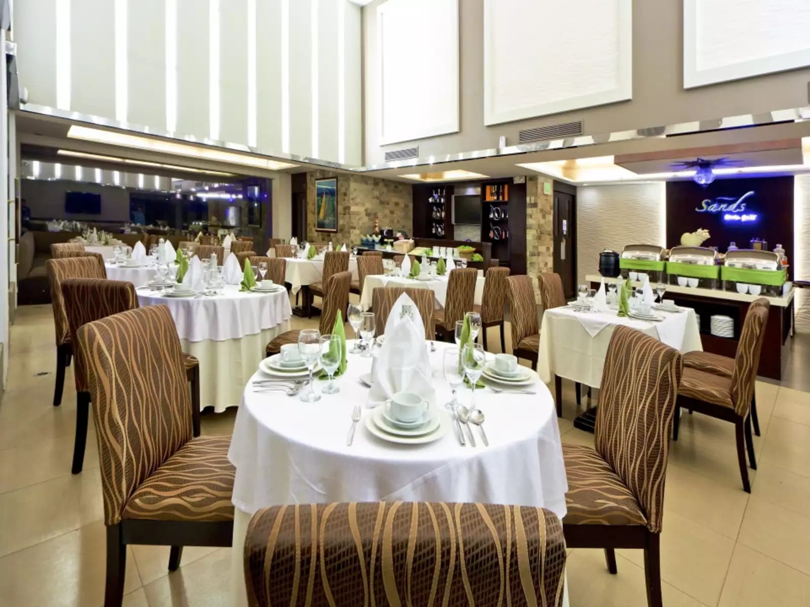 high ceiling gathering space in zambales with round dining tables and buffet section