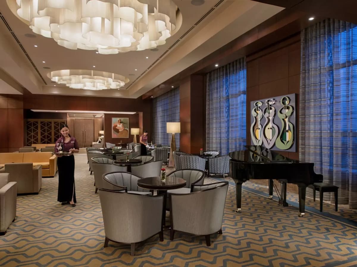 private business lounge area featuring gleaming chandeliers and grand piano hotel alabang