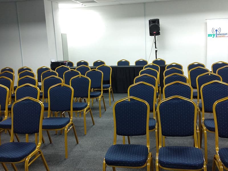 kuala lumpur event space with speaker and golden-blue chairs