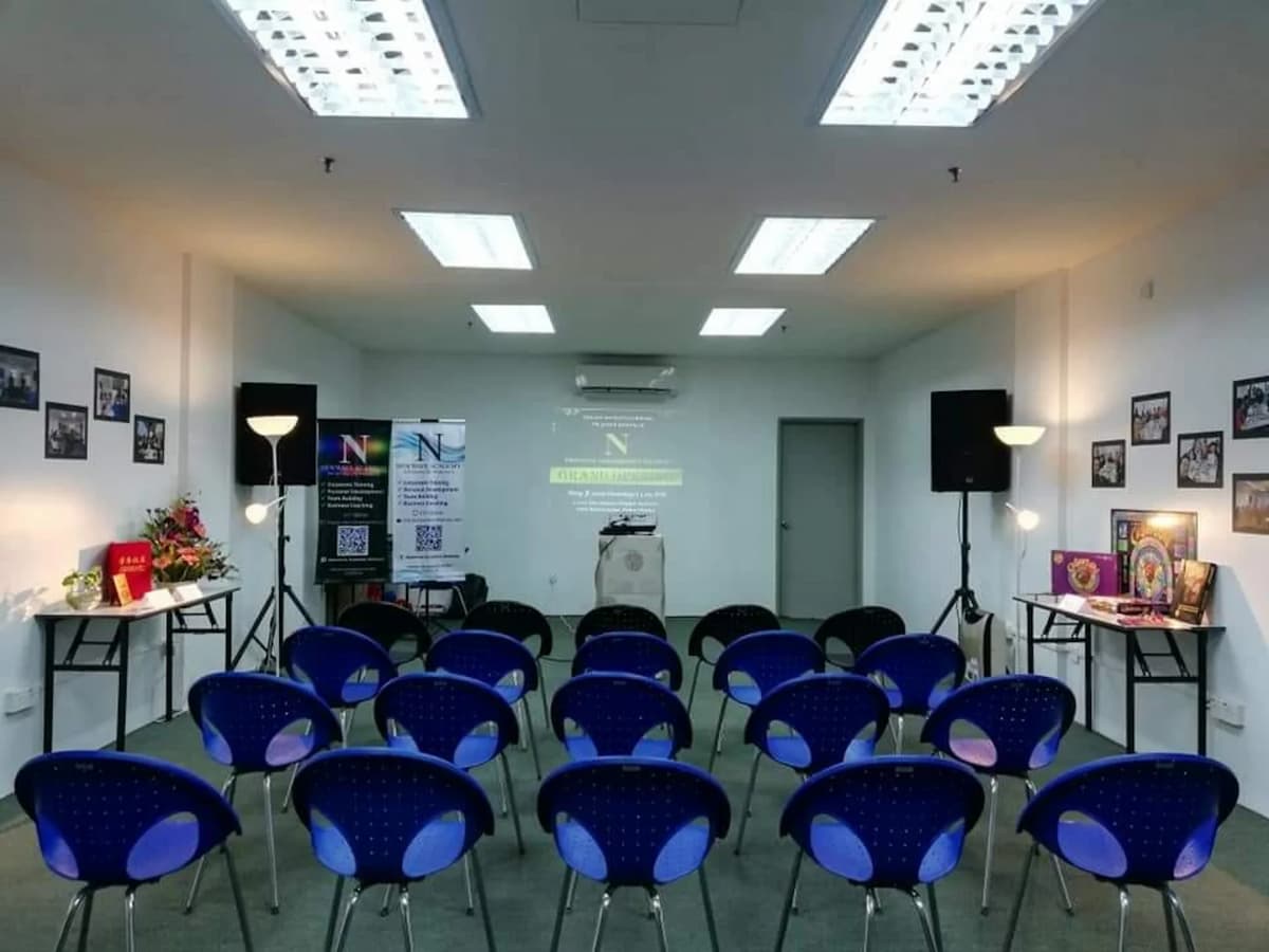 small workshop room in penang with blue chairs and speakers