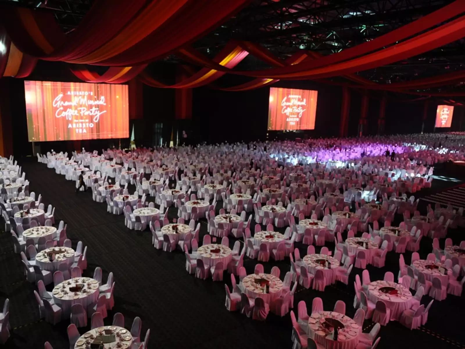 big corporate dining event with round table set up and big stage