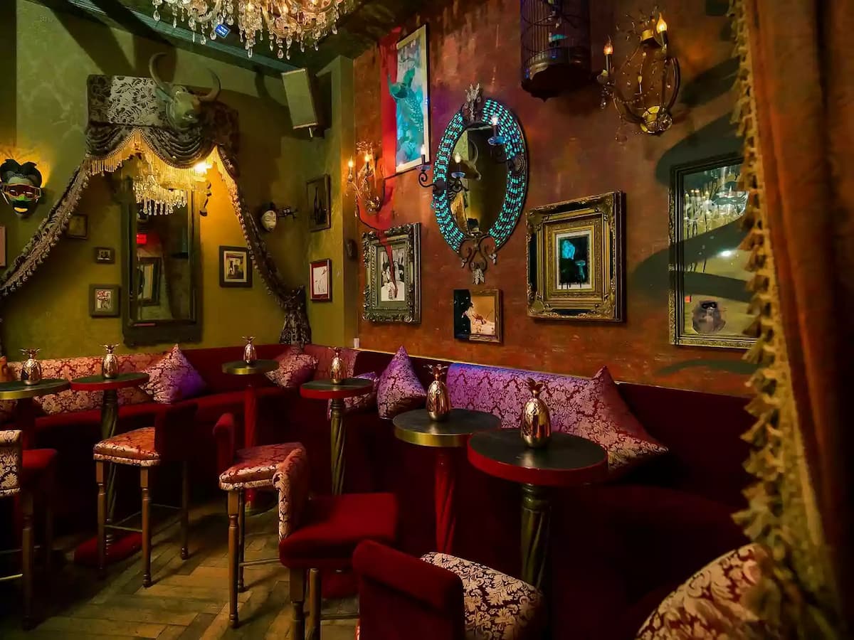 unique bar using red couch and a lot of art decoration on the wall