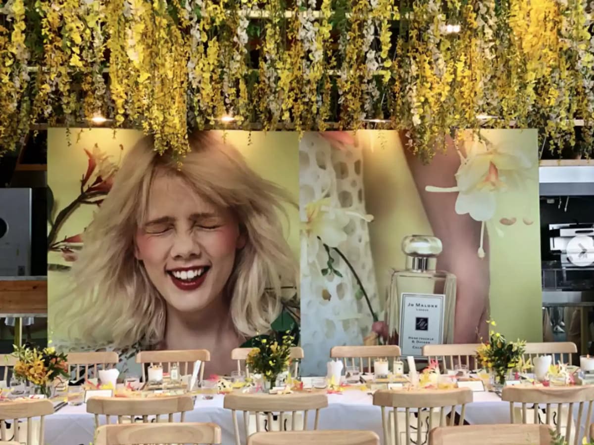 product launch event of parfume brand with woman backdrop and yellow flower decoration
