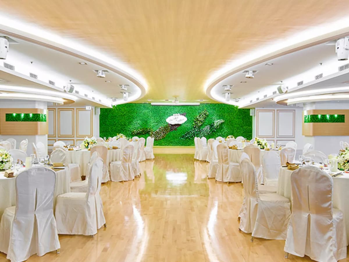 banquet style of ballroom with green backdrop on the stage