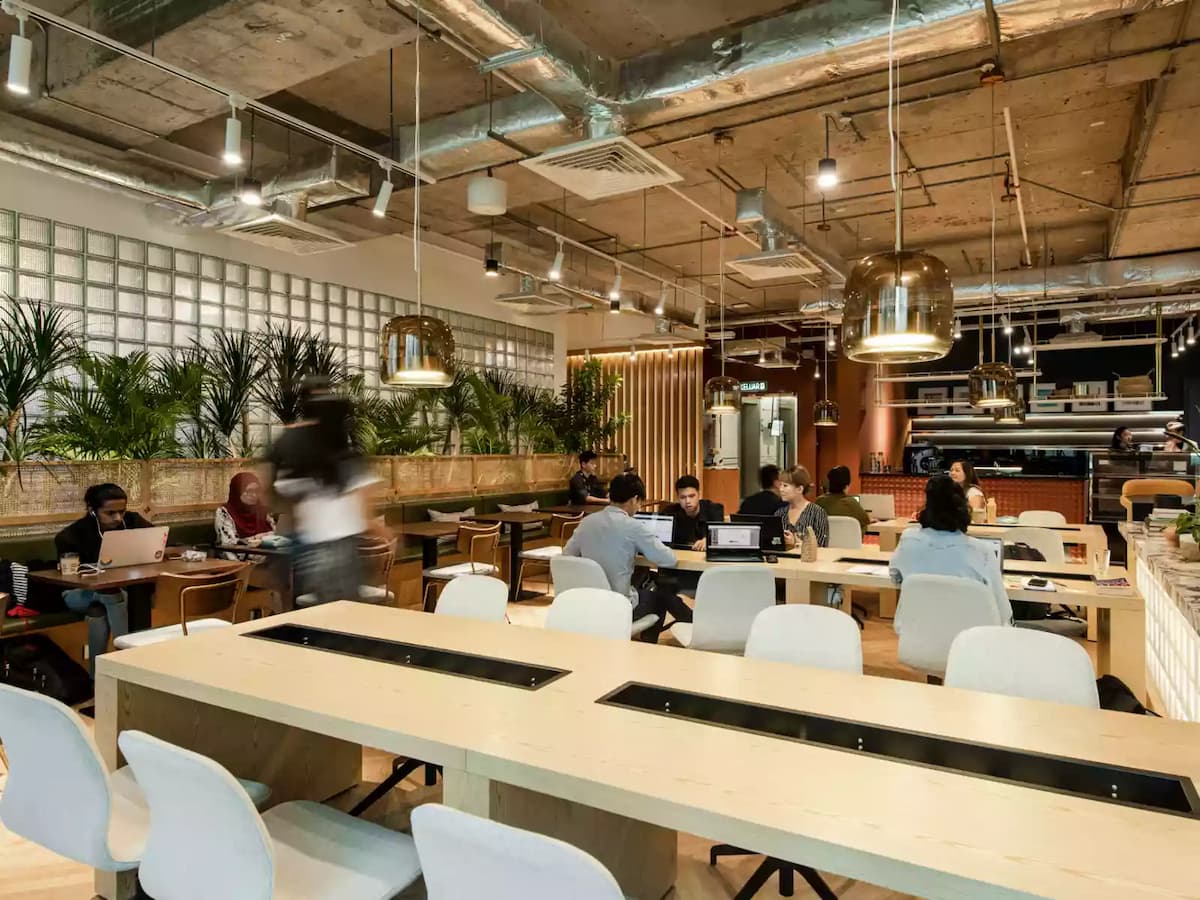 people working at shared desk around coworking area