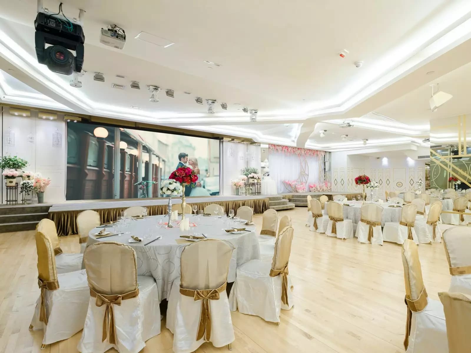 round table setup inside the grand ballroom with couple photo as the backdrop