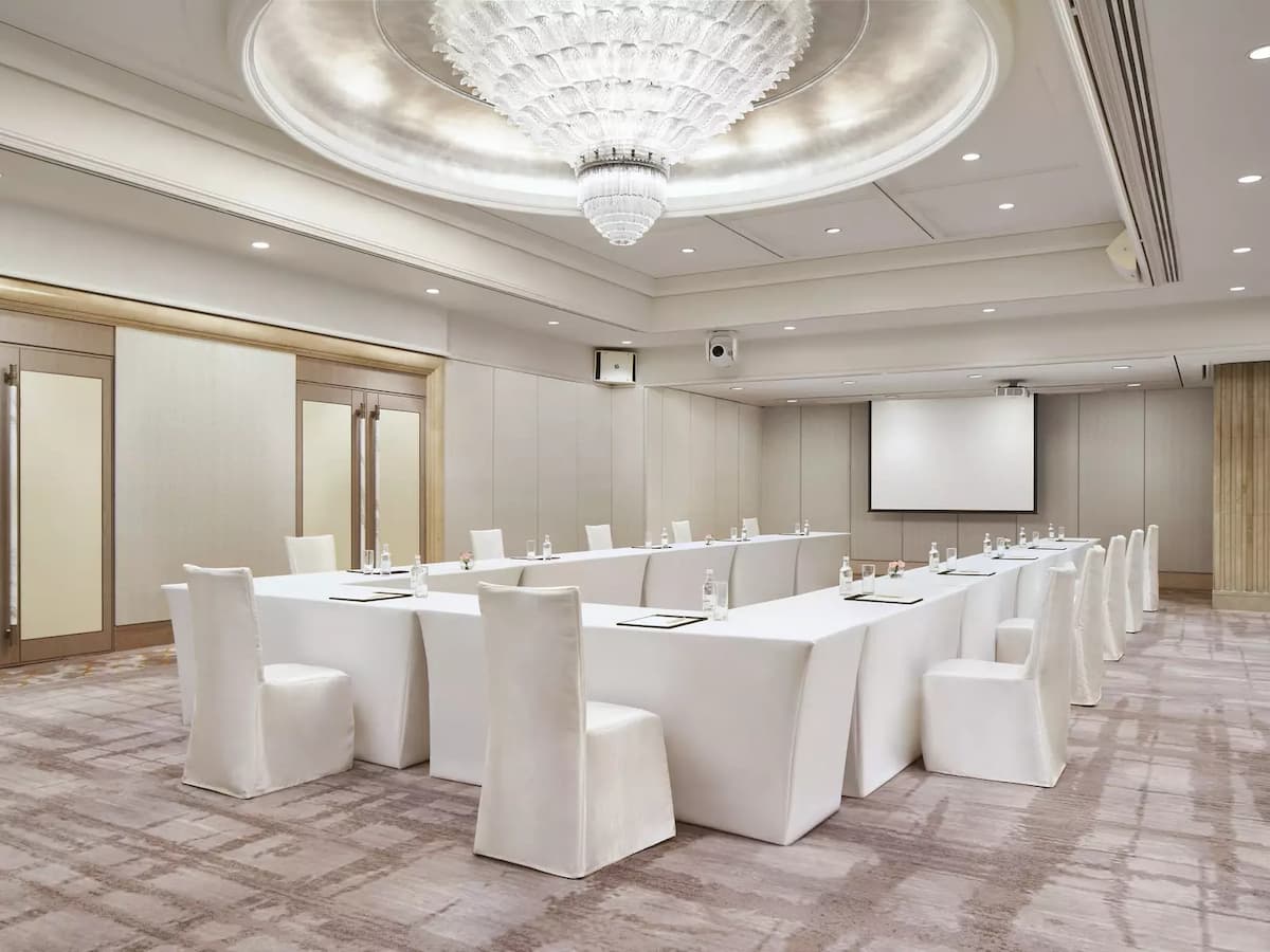 a large meeting room with white tables and chairs