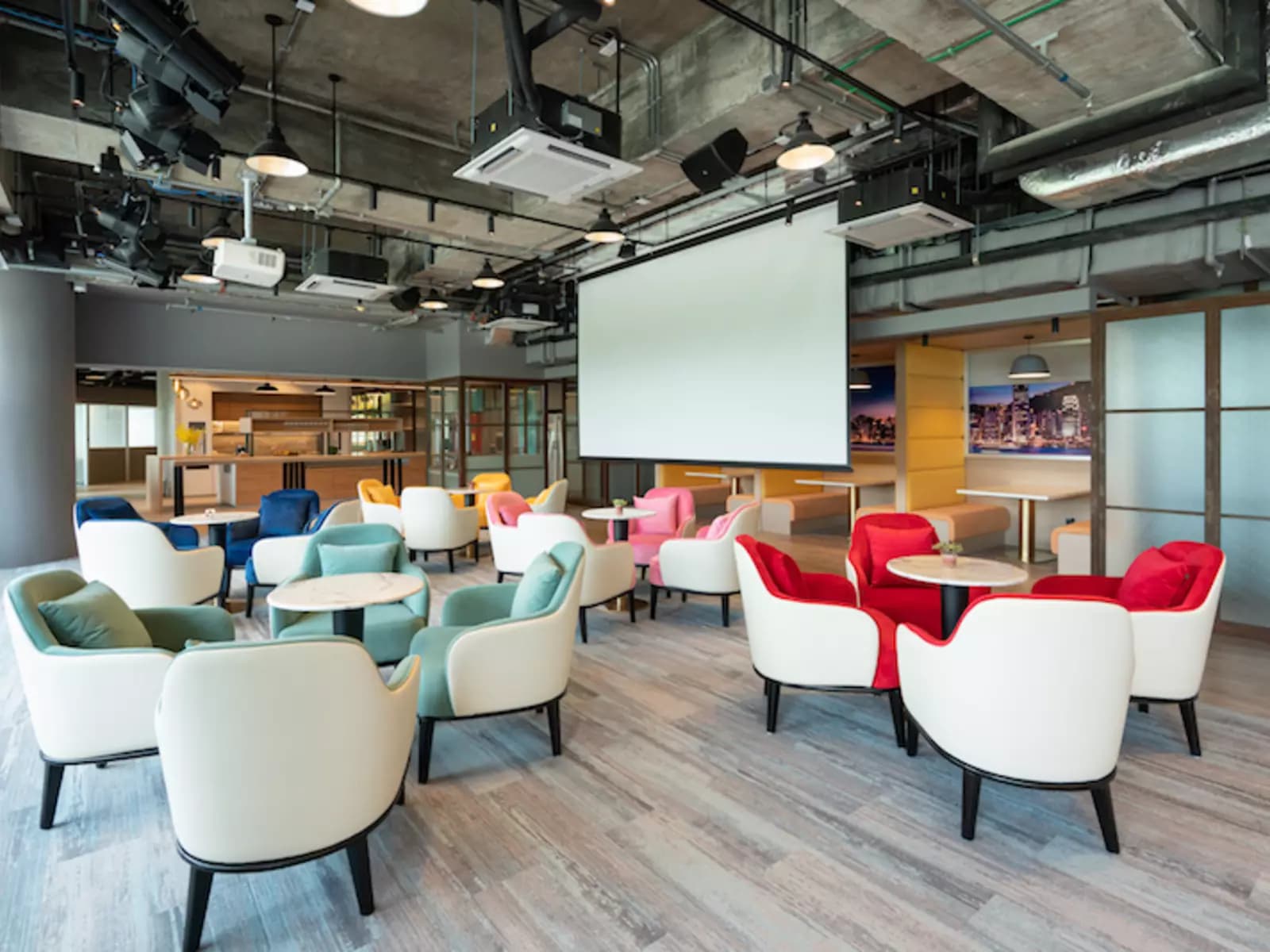 Rainbow colored cushion chairs around small round tables in common area