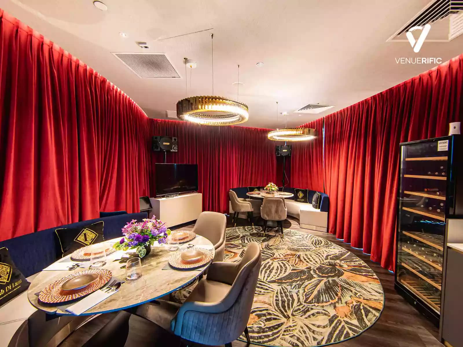 Private room with red curtains, wine refrigerator, and marble chairs and tables