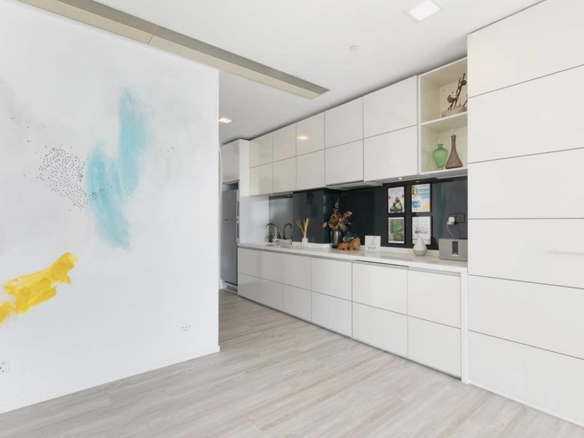 Long shelf with white cabinets and diffusers on it
