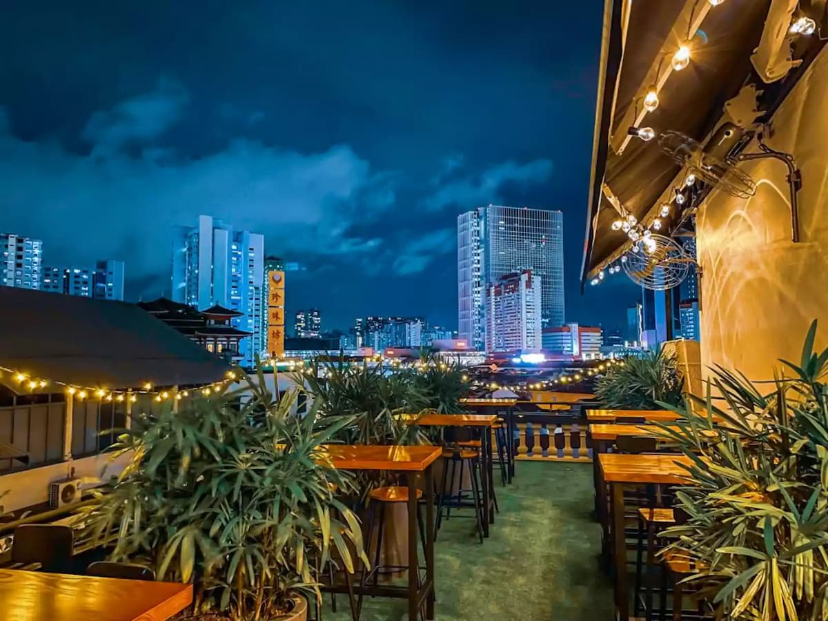 office party venue singapore with rooftop bar and wooden tables and fairy lights for rent