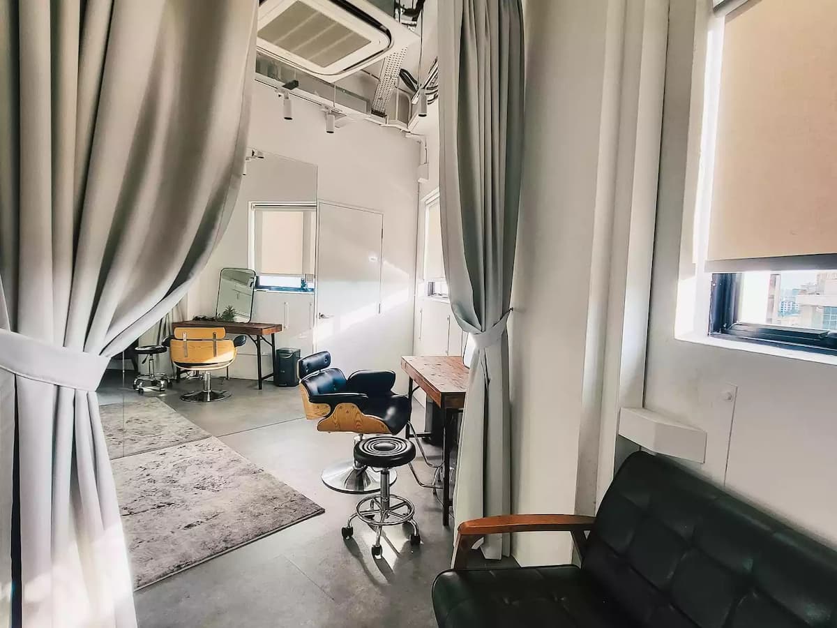 dressing room with black leather makeup chairs facing vanity mirrors