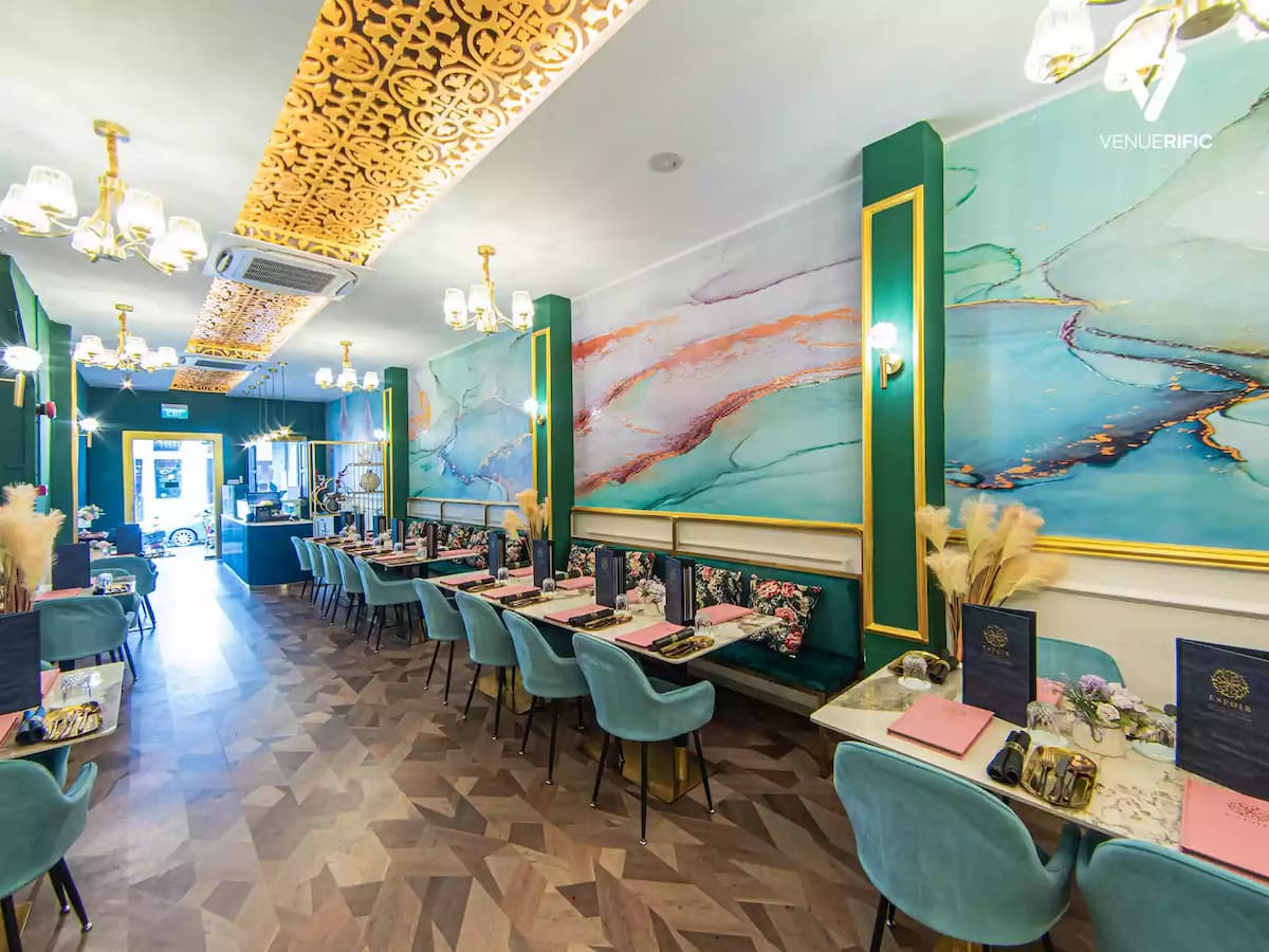 decorative restaurant with teal cushion chairs and marble tables