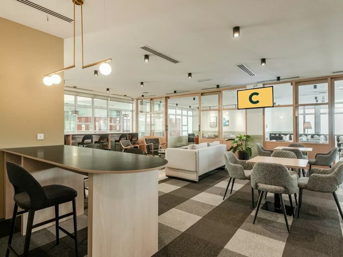 big shared space with carpeted floors, sofas, and plush chairs