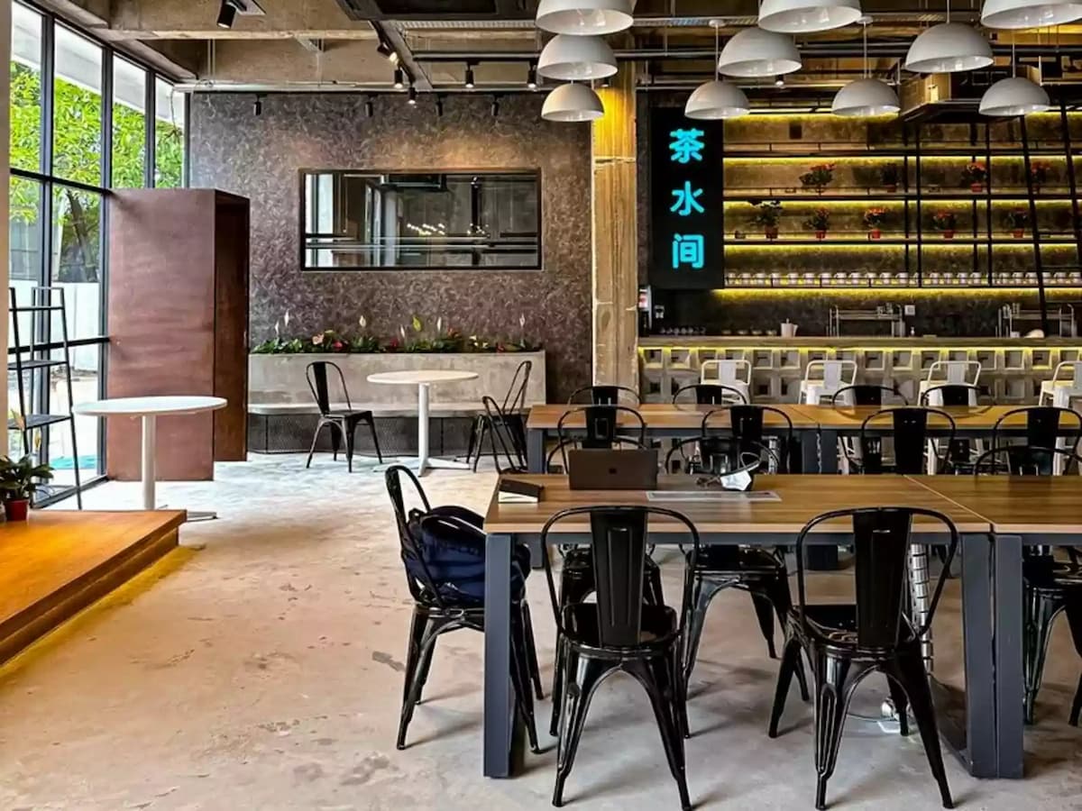 pantry bar counter with neon sign and shared work tables inside a cafe style event space in bandar sunway