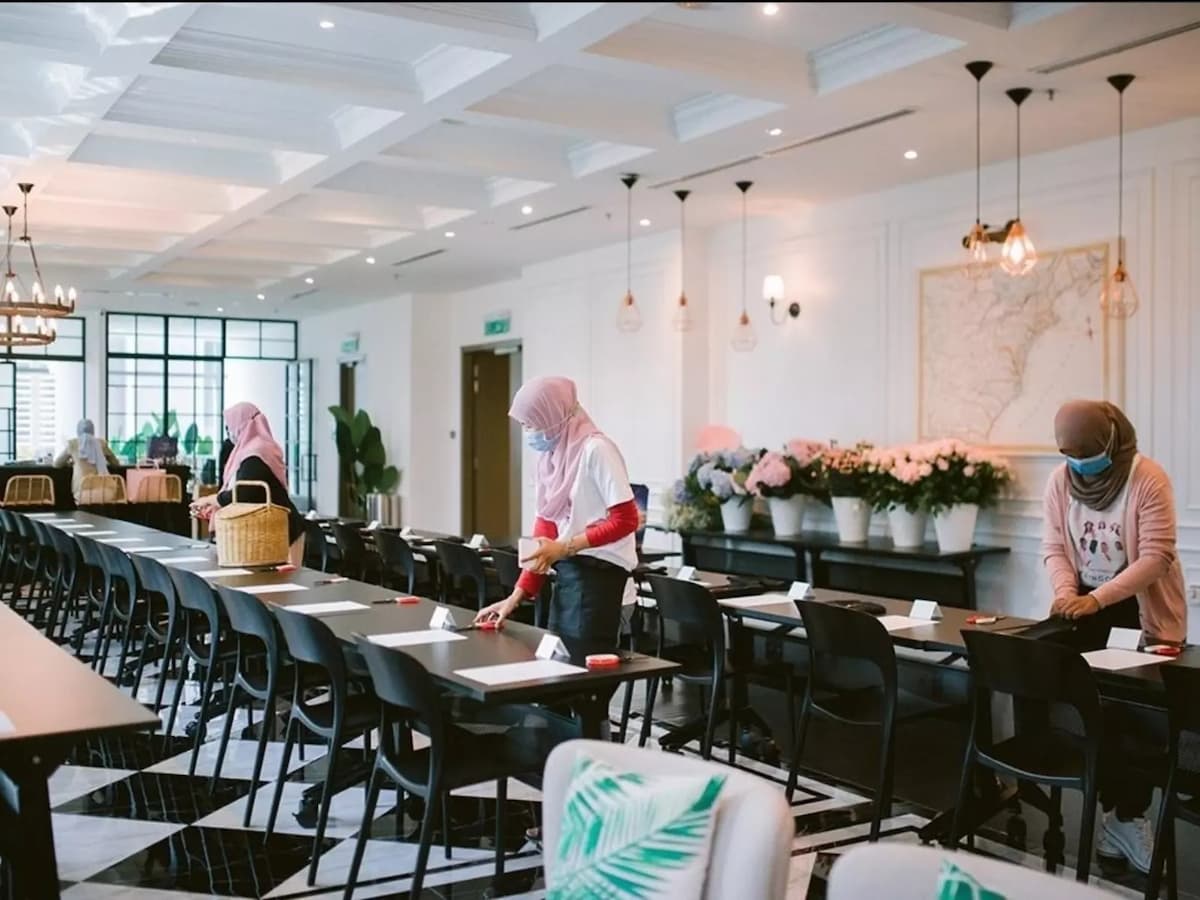 staff setting up classroom style tables and flowers for a seminar at urban loft space event space in kl eco city