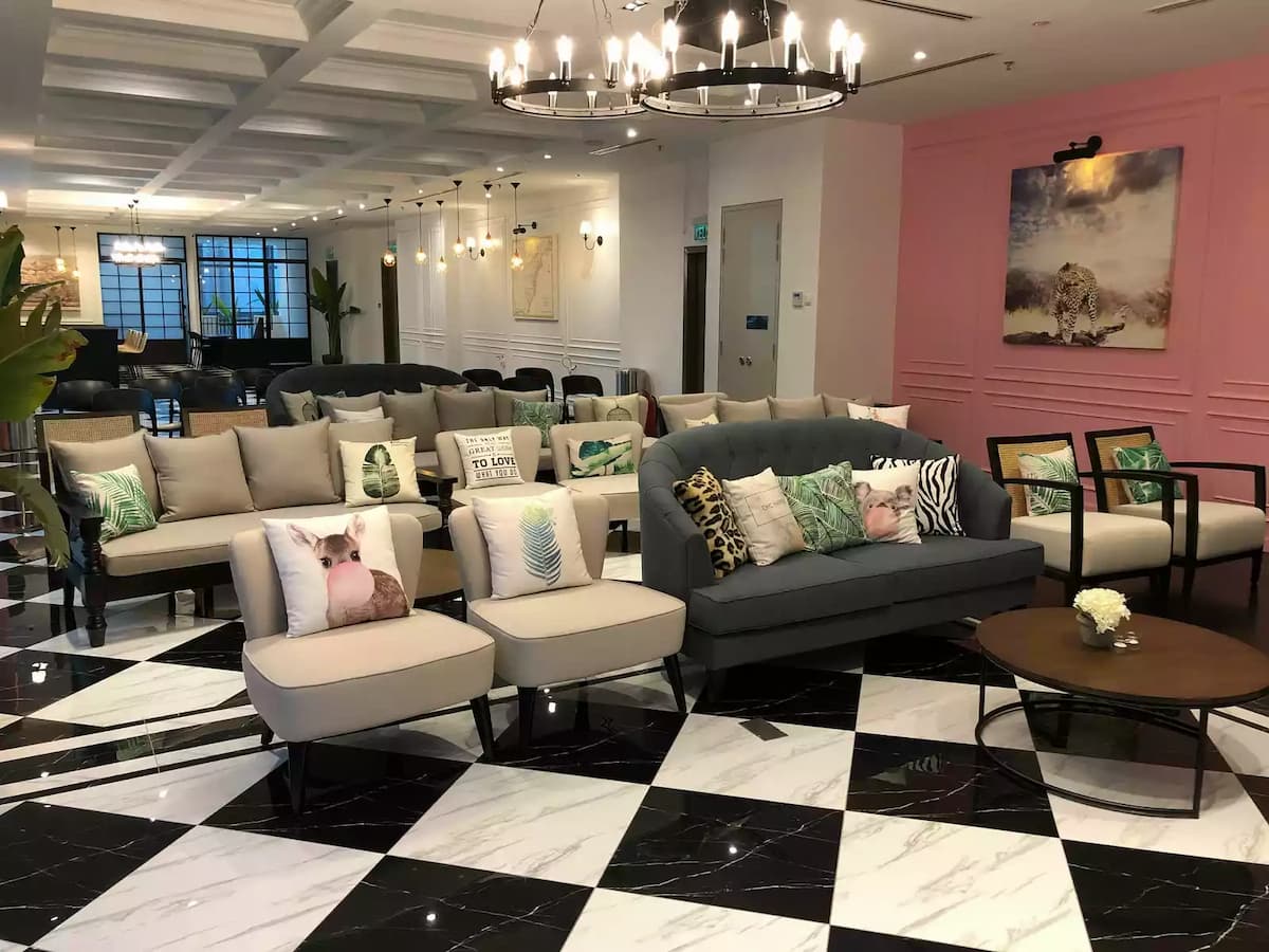 beige lounge chairs with tropical cushions beside a pink feature wall at urban loft space event venue in kuala lumpur