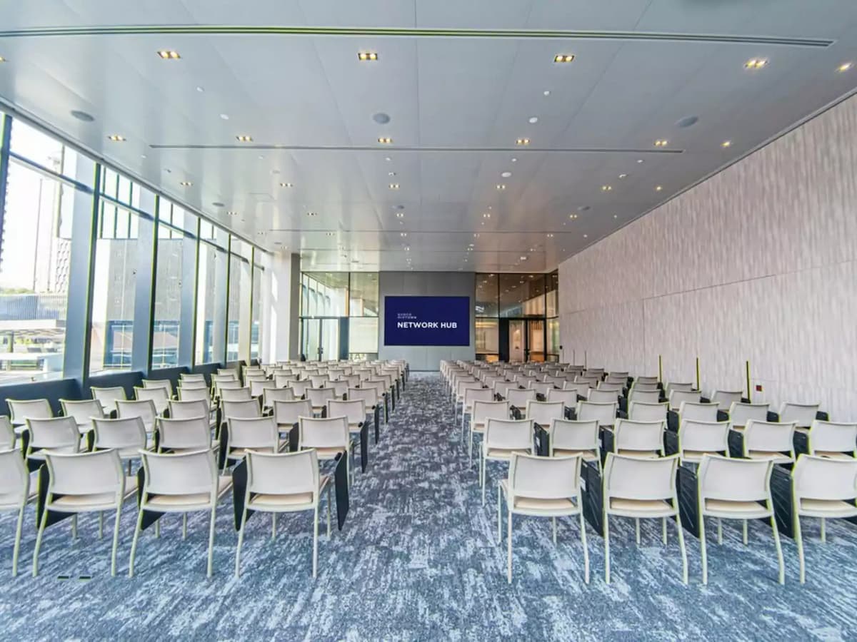 large high ceiling room with large screen in front