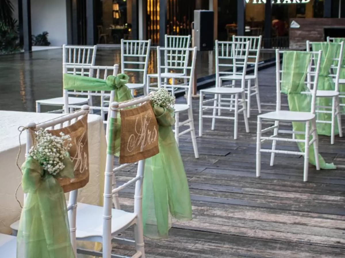 wedding chair setup with green ribbon decor