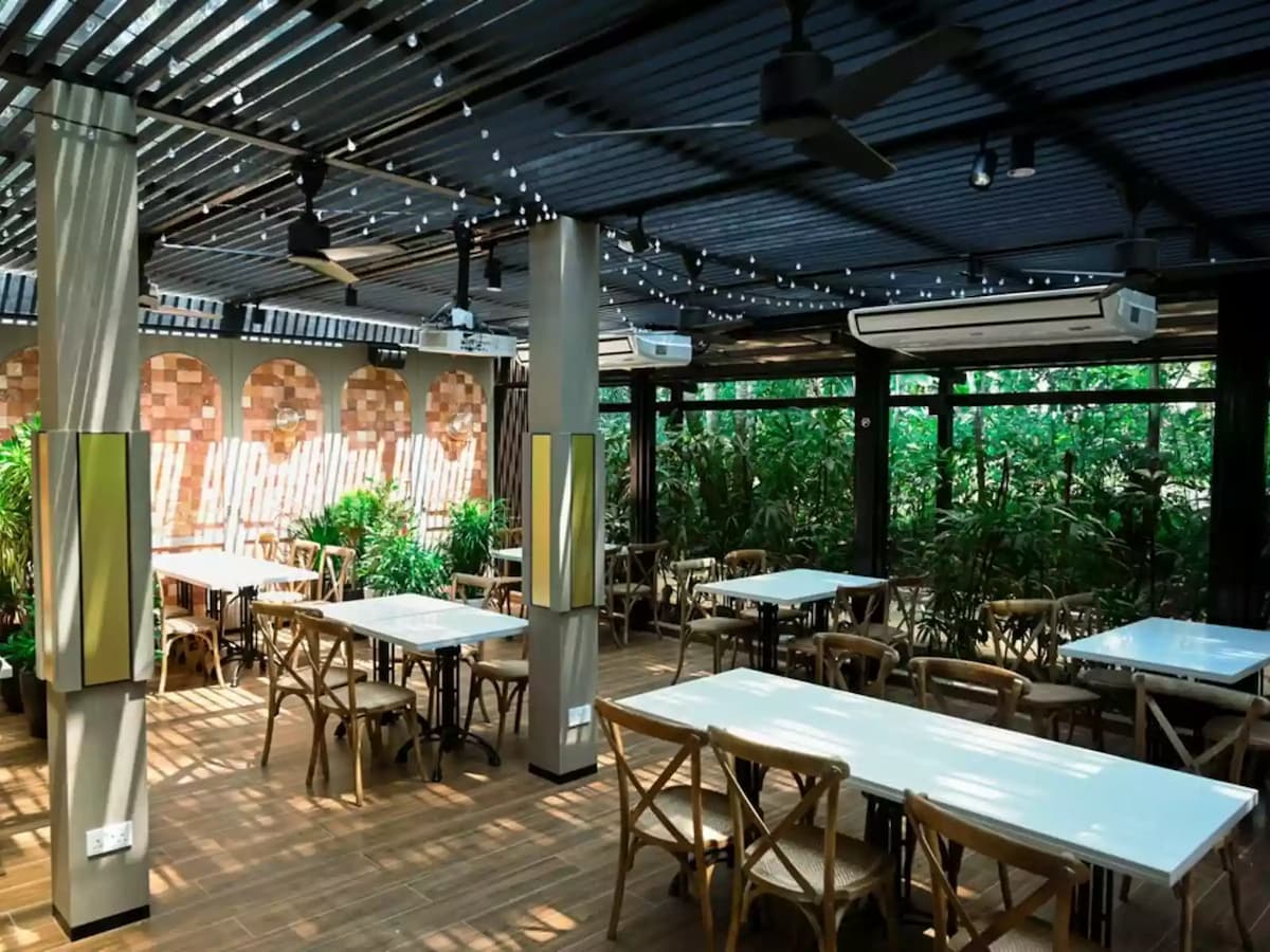 outdoor dining area with wooden tables and chairs and string lights