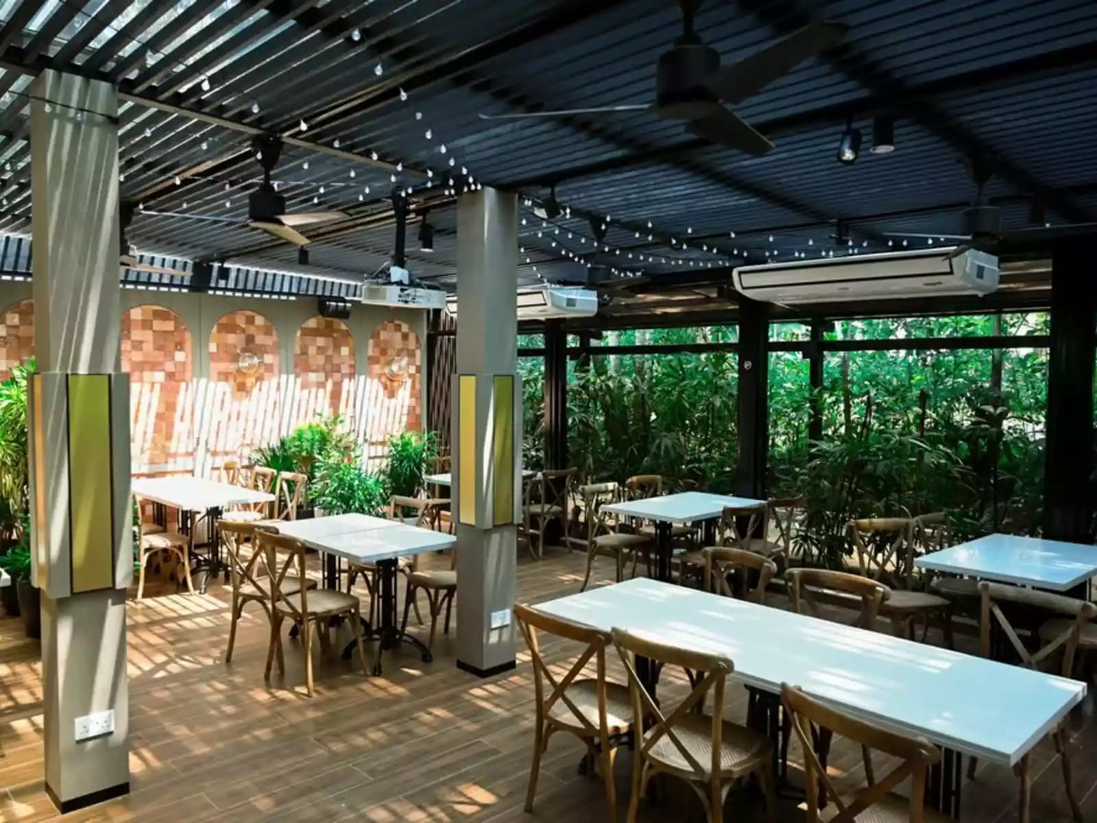 outdoor dining area with wooden tables and chairs and string lights