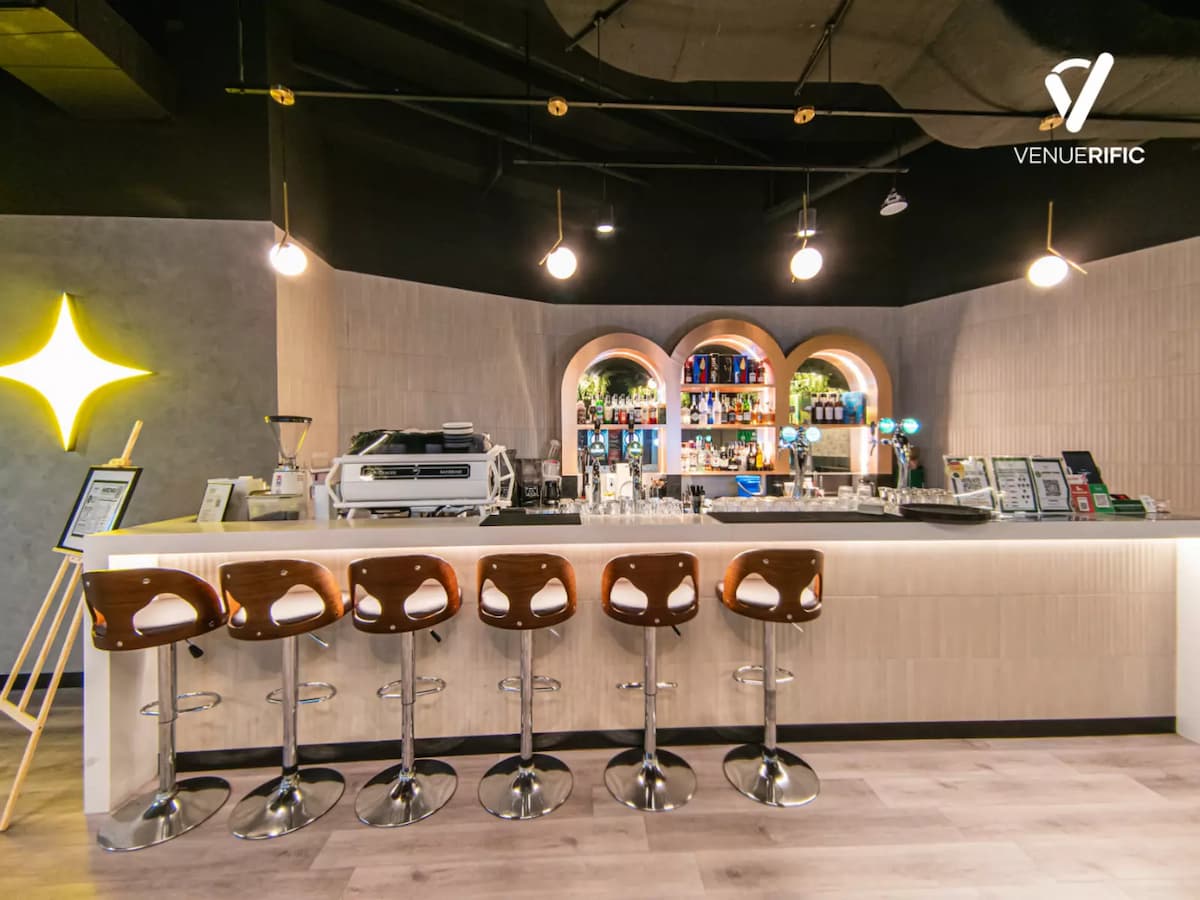 retro bar look with high chairs hanging lights and shelves of alcoholic drinks
