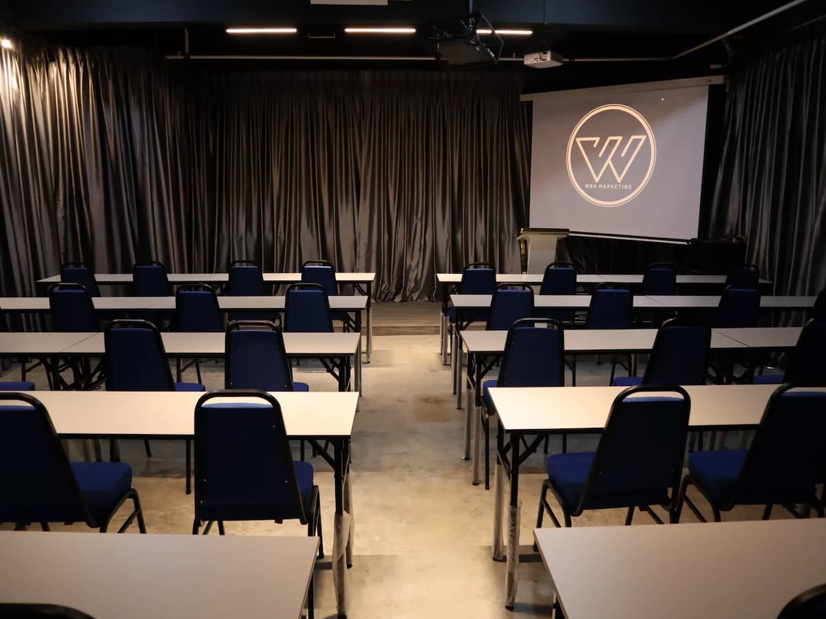 row of tables and chairs in corporate room with projector