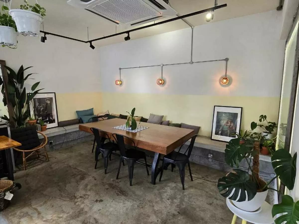 modern design room with wooden tables and black steel chairs and unique wall lamps and potted plants