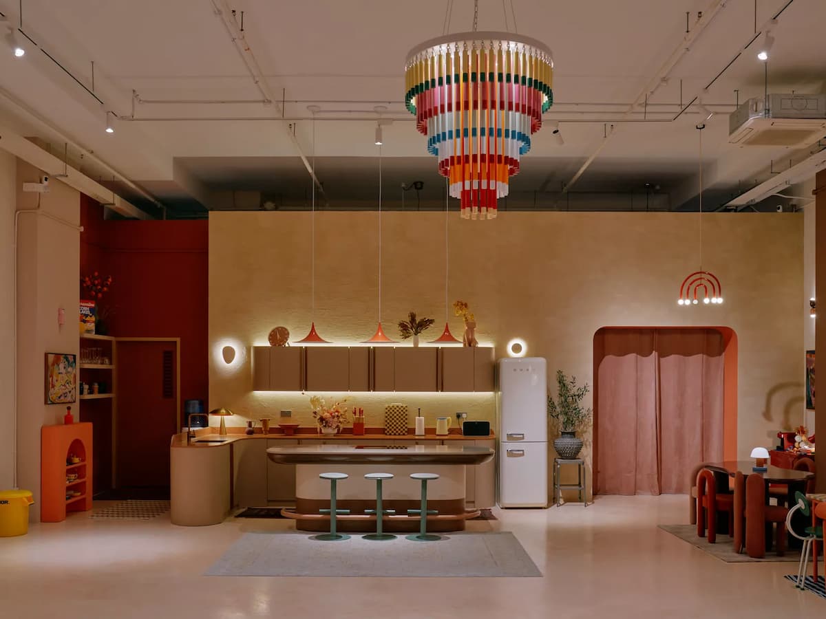 colourful chandelier above kitchen island with teal stools at creative lifestyle studio event space in kallang singapore