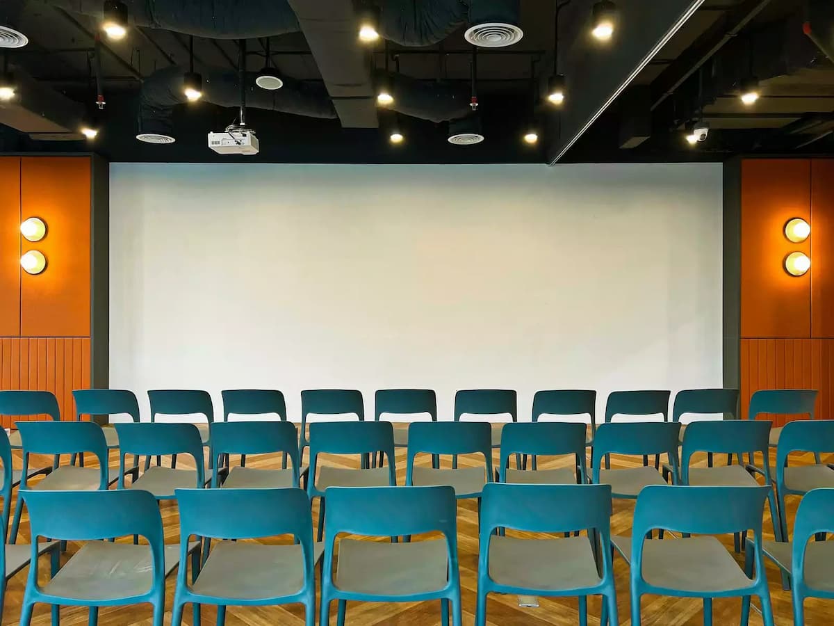 seminar room with teal chairs facing a projection wall and ceiling projector for corporate talks in bangsar kuala lumpur