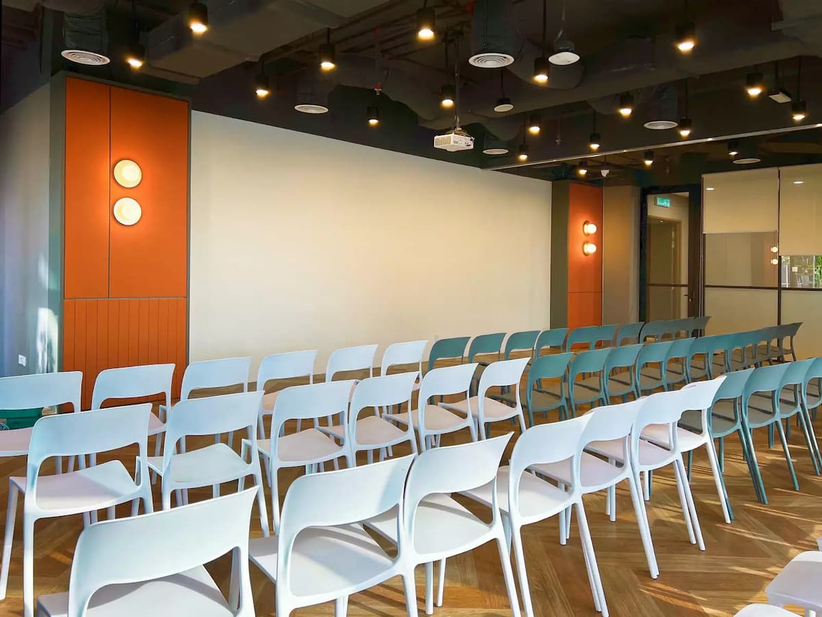 event hall with rows of chairs ceiling projector and orange feature columns set up for product launches in bangsar kuala lumpur
