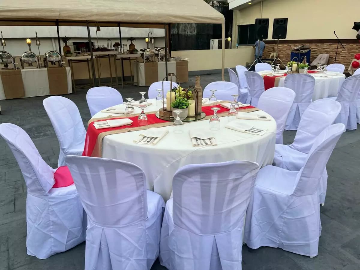 round table with candles, plants, and view of catering table