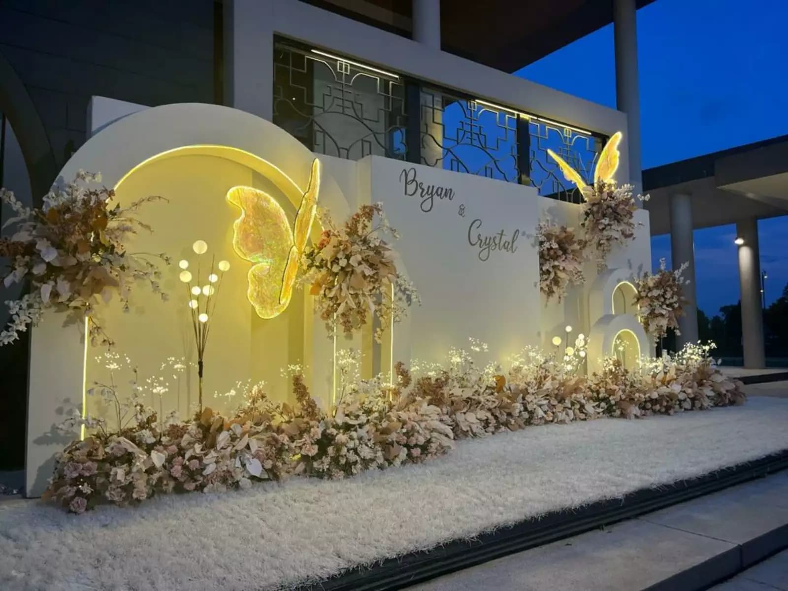 a yellow wedding backdrop with butterflies and flowers