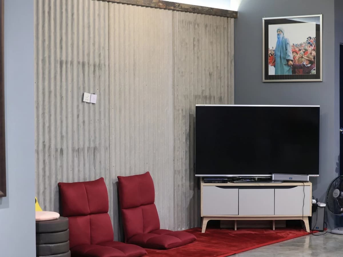 tv lounge area with red cushions and industrial decor at inner journey meditation and wellness center in kuala lumpur