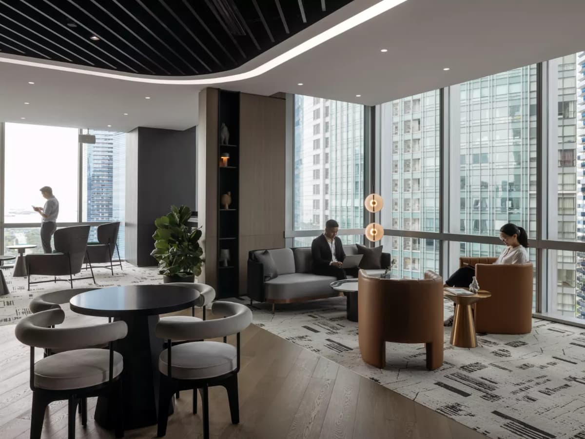 people are seated in a modern and sophisticated lounge with large windows offering a city view