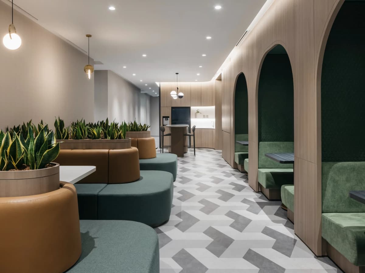 a space features geometric patterned flooring, green plants, and elegant lighting fixtures